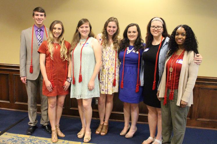 A group photo of Theta members receiving their graduation cords.