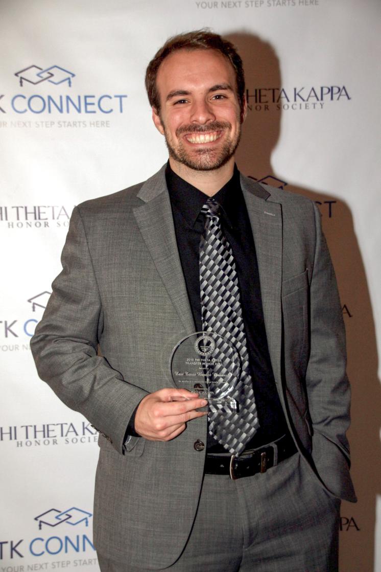 ETBU Transfer Admissions Counselor Max Turner accepts an award on the behalf of the University at the PTK Catalyst 2019. East Texas Baptist University was one of only 78 institutions in the nation named to the Phi Theta Kappa Honor Society Transfer Honor Roll.