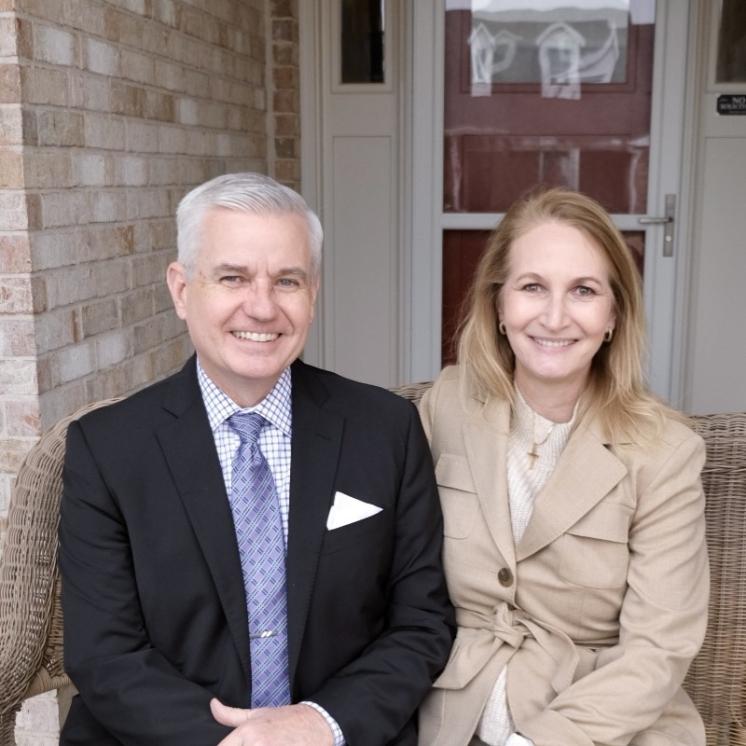 A man and woman sitting in front of a door