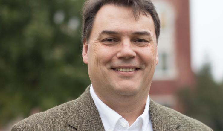 John Dement Man smiling at the camera with a building in the background